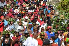 a large group of people standing in front of each other with plants on their heads