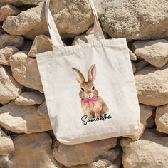 a tote bag with an image of a rabbit wearing a pink bow on it