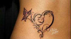 a woman's stomach with a butterfly and heart tattoo on the side of her belly