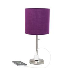 a purple lamp with a remote control next to it on a white background, and a phone plugged into the charger