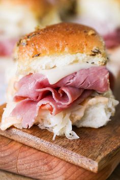 a ham and cheese sandwich sitting on top of a cutting board