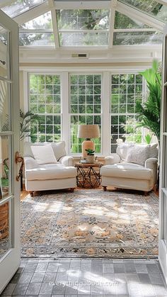 a sun room with two couches and a rug on the floor in front of it