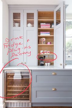 a kitchen with white cabinets and red writing on the wall next to an open oven