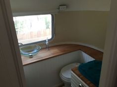 a bathroom with a sink, toilet and window