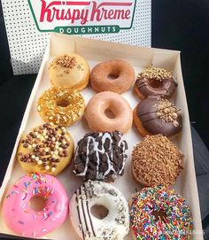 an open krispy kreme doughnut box filled with assorted donuts