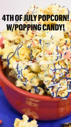 a red bowl filled with popcorn covered in sprinkles on top of a blue table