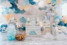 a baby shower party with blue and white balloons, cake and other items on the table