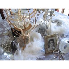 a table topped with white feathers and pictures