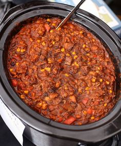 a crock pot filled with chili and corn