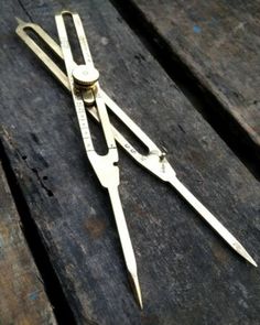 a pair of scissors sitting on top of a wooden table next to a bottle opener