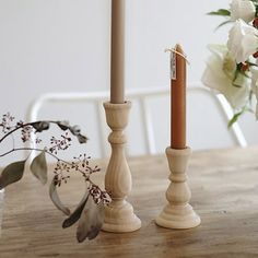 two candles sitting on top of a wooden table