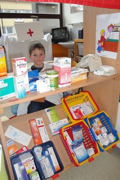 a young boy sitting at a table with many boxes and containers on it