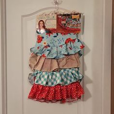 a door hanger is decorated with ruffled fabric and an image of a woman