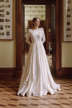 a woman in a white wedding dress standing on a checkered floor