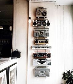 there is a wall hanging with old radio's on it