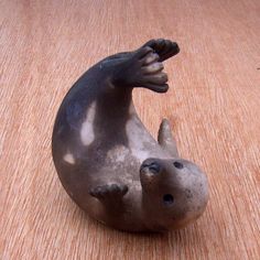 a small statue of a seal on a wooden surface