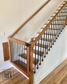 a wooden banister next to a white wall