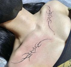 a woman laying down with her back turned to the camera and tattoos on her chest