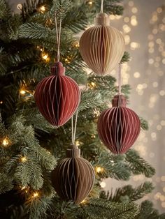 three paper ornaments hanging from a christmas tree