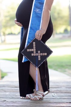 a pregnant woman wearing a blue sash and holding a crossword puzzle on her belly