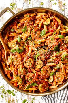 a pan filled with pasta and vegetables on top of a table