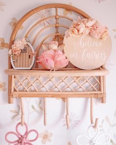 there is a wooden shelf with flowers on it and an umbrella hanging from the wall