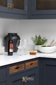 a kitchen counter with two wine glasses and a bowl of food on top of it