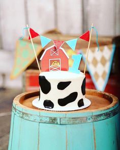 there is a cake that has been decorated with a cow on it and flags in the shape of a barn