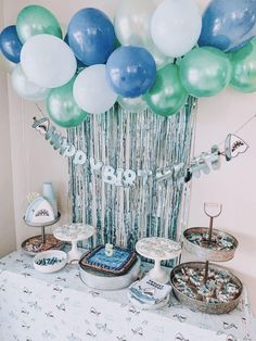 a table topped with lots of cake and balloons