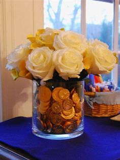 a vase filled with lots of yellow flowers on top of a blue table next to a basket