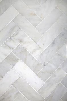 a white marble herringbone pattern on the floor