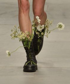 a woman's legs with flowers in them on the runway at london fashion week