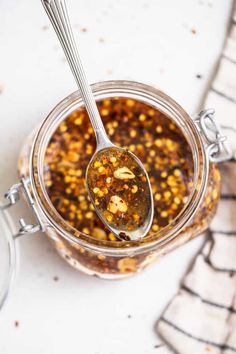 a glass jar filled with food and a spoon on top of the jar next to it