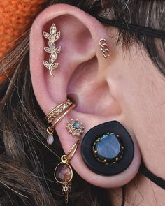 a close up of a person's ear with different types of jewelry on it