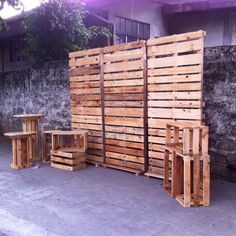 several wooden pallets stacked on top of each other in front of a building with concrete floors