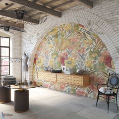 a living room filled with furniture next to a brick wall covered in colorful floral designs