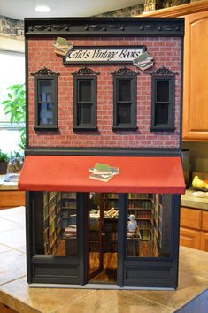 a doll house made to look like a book store with red awnings and windows