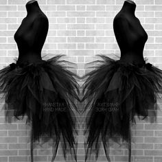 two mannequins with black tulle on display in front of a brick wall