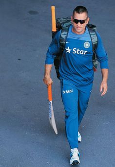 a man walking down the street with a backpack on his back and a bat in his hand