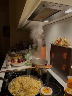 a kitchen filled with lots of food and cooking utensils on top of a stove