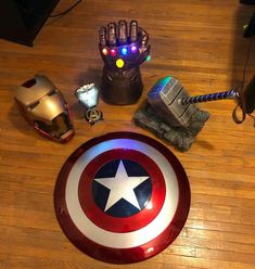 an iron man helmet sits on top of a wooden table next to other avengers items