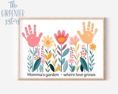 a framed print with flowers and hand prints on it, says momma's garden - where love grows