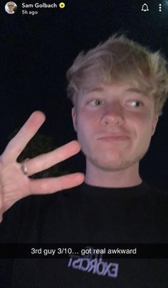 a young man making the vulcan sign with his hand while wearing a black t - shirt