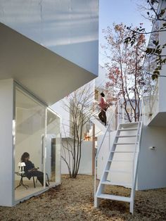 a person sitting on a chair next to a stair case in front of a building