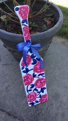 a pink and blue flowered tie sitting on top of a potted planter