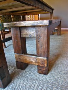 a table made out of wooden planks on top of carpeted floor next to wall