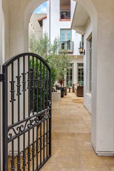 an arched iron gate leads into a courtyard