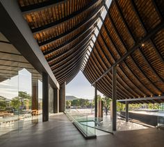 the inside of a building with glass walls and wood roofing on it's sides