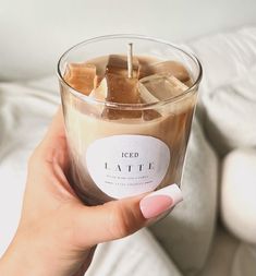 a person holding a cup with ice and chocolate in it