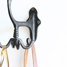 an old pair of scissors hanging on a wall with leather straps attached to it's handles